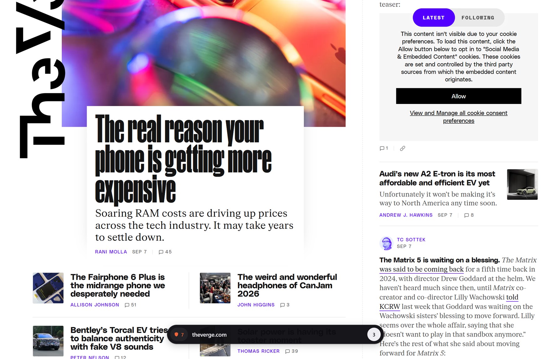 A news site filling the whole window edge to edge, with no toolbar and no tab strip. A single dark rounded pill floats near the bottom centre showing an orange shield with the number 7, the host name theverge.com, and a white circle with a 3 in it