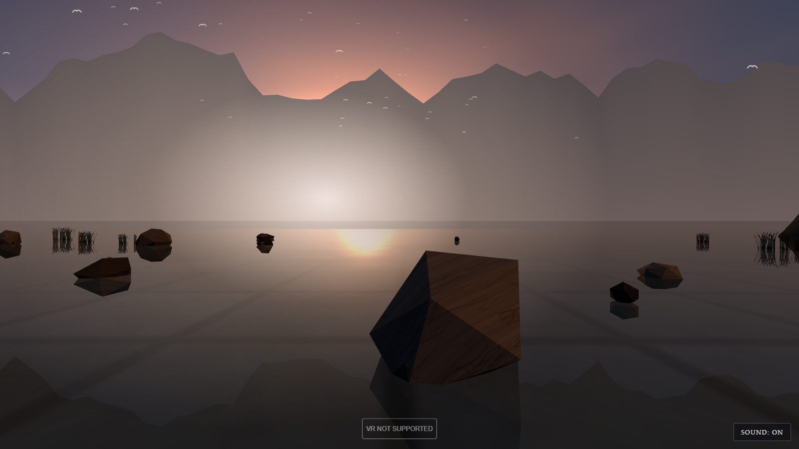 The far side of the gate: an open lake of still water under a hazy pink and violet sky. A pale sun glows low in the haze above a long ridge of grey mountains, and its reflection sits on the water. A few dark boulders and clumps of reeds stand in the shallows, with seagulls scattered across the sky