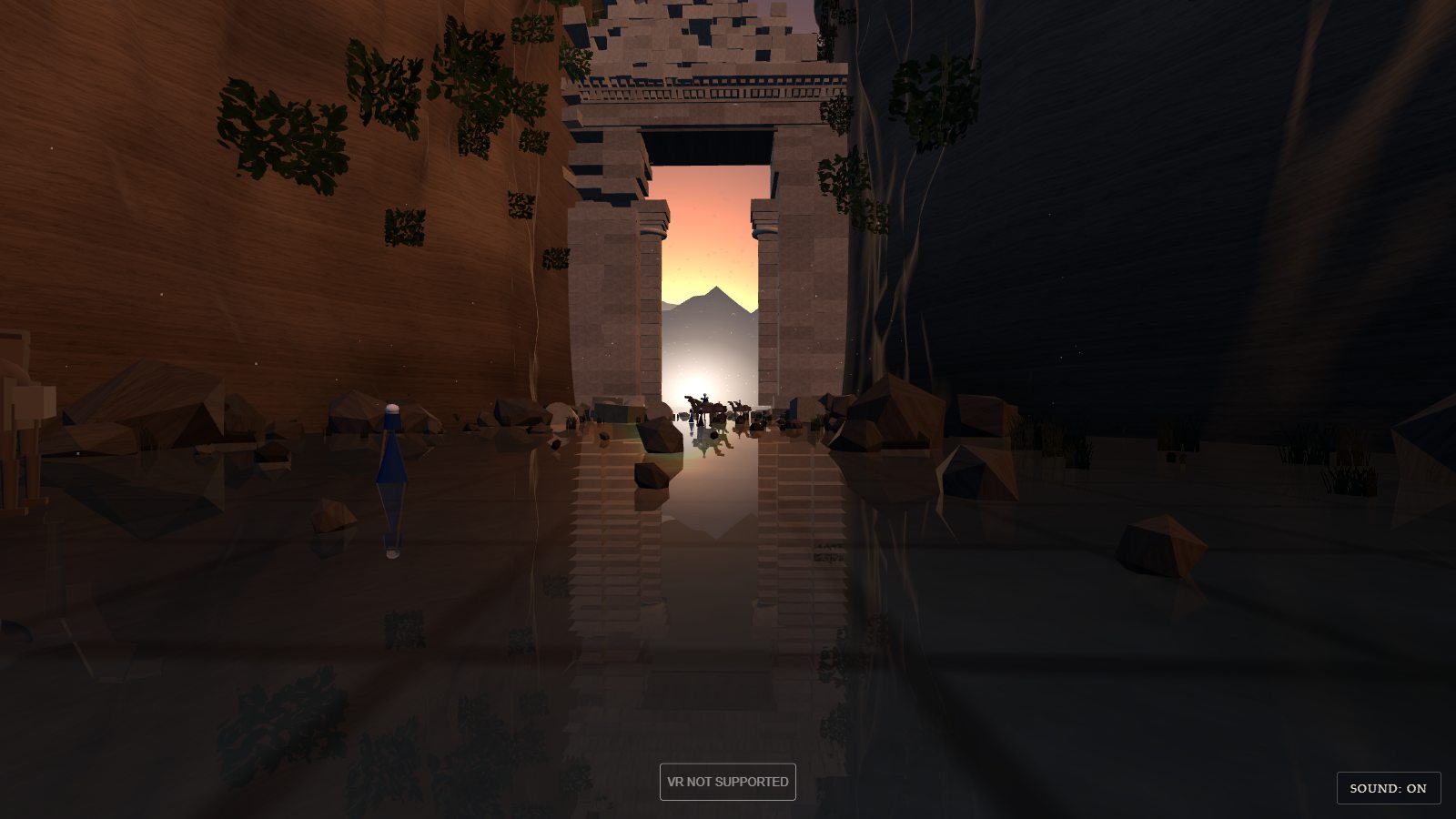 Looking down a narrow gorge at dusk. The left wall is warm brown sandstone with tufts of green, the right wall is in deep blue shadow. The gorge floor is a sheet of still water reflecting everything. At the far end a ruined stone gate fills the gap between the walls, with columns, a carved lintel and broken masonry above; through its opening a pink and orange sky, a pale mountain, and the silhouettes of a camel caravan. A small figure in a blue robe stands in the water on the left